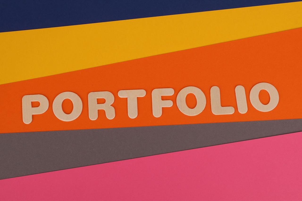 Un fond multicolore et dynamique avec le mot PORTFOLIO en police rose sur du papier coloré.